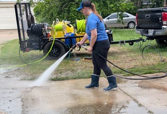 Women washing a drive way with a pressure washer