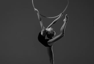 Young rhythmic gymnast performing with a hoop during photo session.