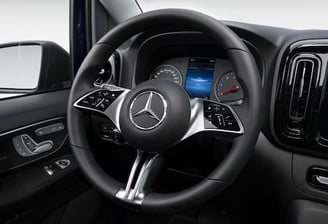 Volant d’un Mercedes Vito noir en location, avec tableau de bord visible en arrière-plan