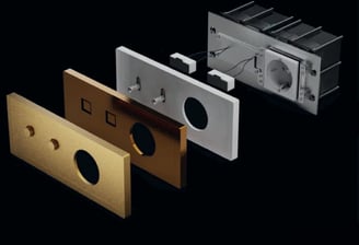 Explosión de componentes de interruptores de lujo con acabados metálicos y tecnología avanzada