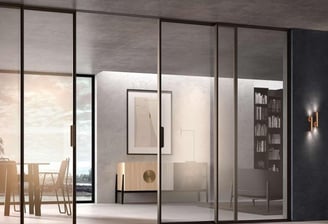 Cerramiento de cristal corredero con marcos oscuros en comedor de diseño minimalista