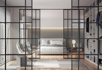 Puerta de vidrio corredera con marco negro en espacio diáfano entre salón y dormitorio contemporáneo