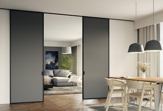 Puerta corredera acristalada con marco negro separando cocina y salón con diseño escandinavo
