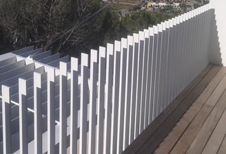Detalle de valla blanca de aluminio con líneas horizontales para exterior de vivienda moderna