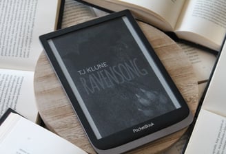 a book is sitting on a wooden table ravensong tjklune