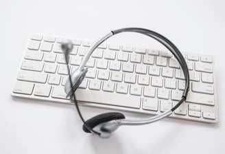 Casque audio avec micro posé sur un clavier d'ordinateur.