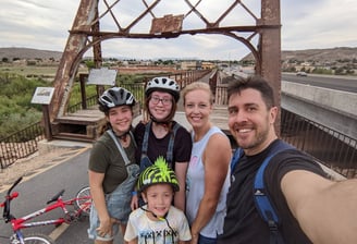 family in front of bridge on bike ride