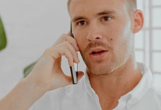 Homme au téléphone demandant un devis pour un service de débarras en Suisse romande