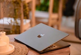 a laptop computer sitting on a table with a candle and a candlelight