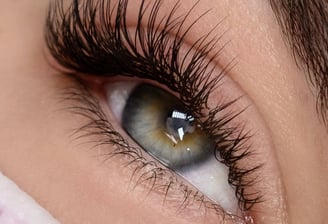 alt="mobile lash technician applying lashes in London home"