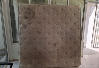 a mattress topper in a room with a chair and a chair