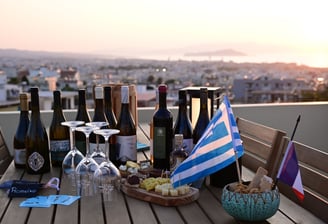 a table with greek wine bottles and glasses on it at La Canée