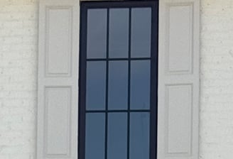 Fixed exterior shutters on a brick home