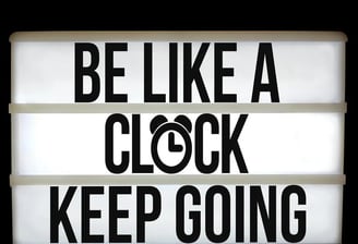 a sign that says be like a clock keep going