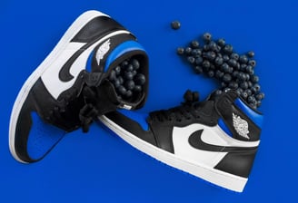 a pair of black and white sneakers with mini black balls, Nike Air Jordan 1