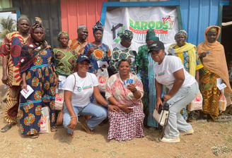 a group of people standing around a woman holding a baby