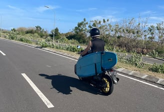 a man riding a scooter with a surfboard