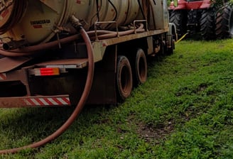 a truck with a large tank sitting on the grass