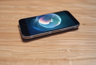 A smartphone with a severely cracked and shattered screen, exposing the inner components. The body of the phone is red, and the damage suggests impact or pressure.