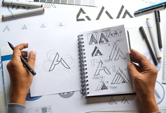 Designer sketching logo concepts at Desynco Studio, showcasing creative design development.