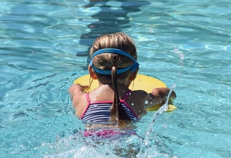 young child learning to swim