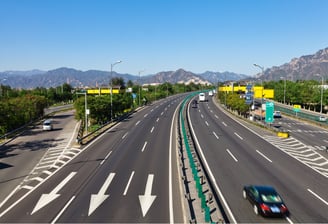 Aerial view of a smart expressway equipped for AI-powered traffic monitoring and dynamic speed management.