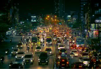 Night view of congested urban traffic with cars and motorcycles under city lights for congestion monitoring.