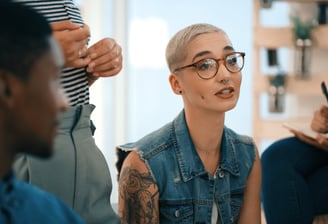 young tattooed woman in creative business meeting