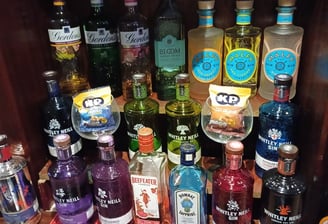 a shelf of gin bottles and liquor bottles