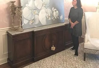 marcine standing next to orchid painting in pennington nj