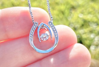 a person holding a diamond necklace with a diamond