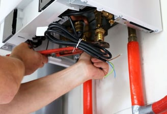 a man is fixing a water heater in a room