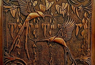 a decorative wooden paneled wall hanging with a bird