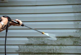 siding being cleaned by a pressure washer