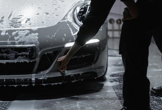 Un homme nettoie une voiture sportive avec une éponge à Toulouse