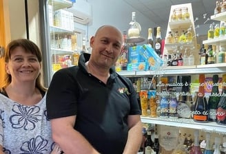 a man and woman standing in front of a store