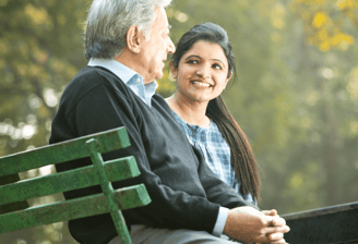 Padre e hija sentados en un jardín, se nota que son empático y con buena relación
