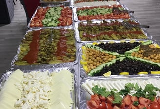 a buffet table with lots of food and people