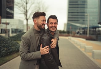 Pareja LGBTQ+ riendo juntos en un momento divertido en la ciudad, foto de boda íntima y con estilo en Madrid