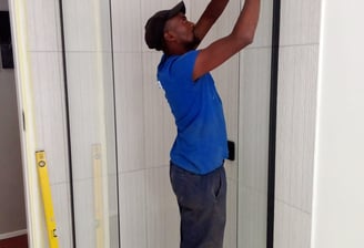 a man in a blue shirt is standing in a shower