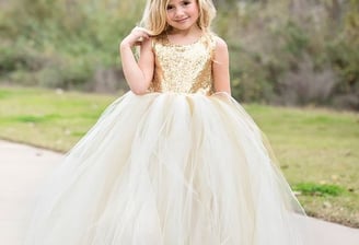 young lady in a beautiful sequined gold and cream party dress