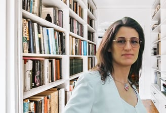 a woman in a white shirt and glasses in a library