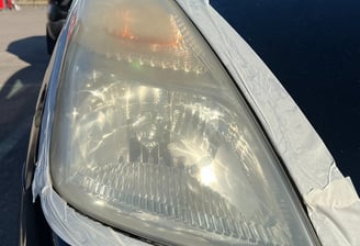 automobilis su balta juostele užklijuotas aplink žibintą, kurį ruošiasi poliruoti