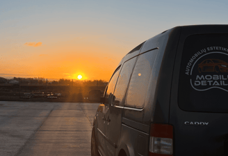 automobilių stovėjimo aikštelėje stovintį furgoną saulei leidžiantis