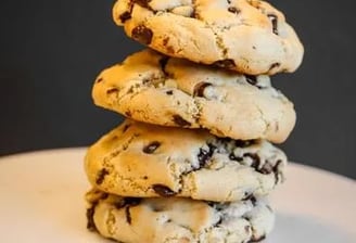 a stack of cookies and chocolate chip cookies on a cake plate