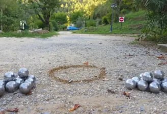 deux amas de boules de pétanques sur un terrain de pétanque