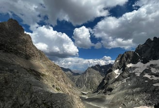 a person standing on a mountain top with a view of a valley