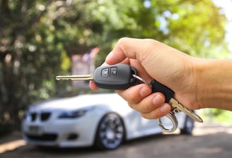 a person holding a car keychain in their hand