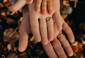 um casal de mãos dadas com alianças de casamento