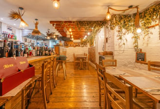 A traditional Italian restaurant with wooden tables and chairs and a bar